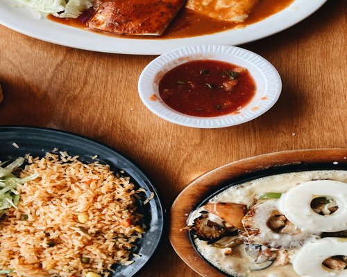 A traditional Colombian meal with fresh avocado, beans, and arepa on a wooden table